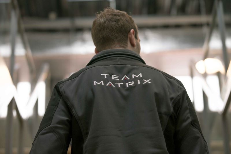 Rugzijde van een man in een vest met een print van het Matrix Fitness-logo